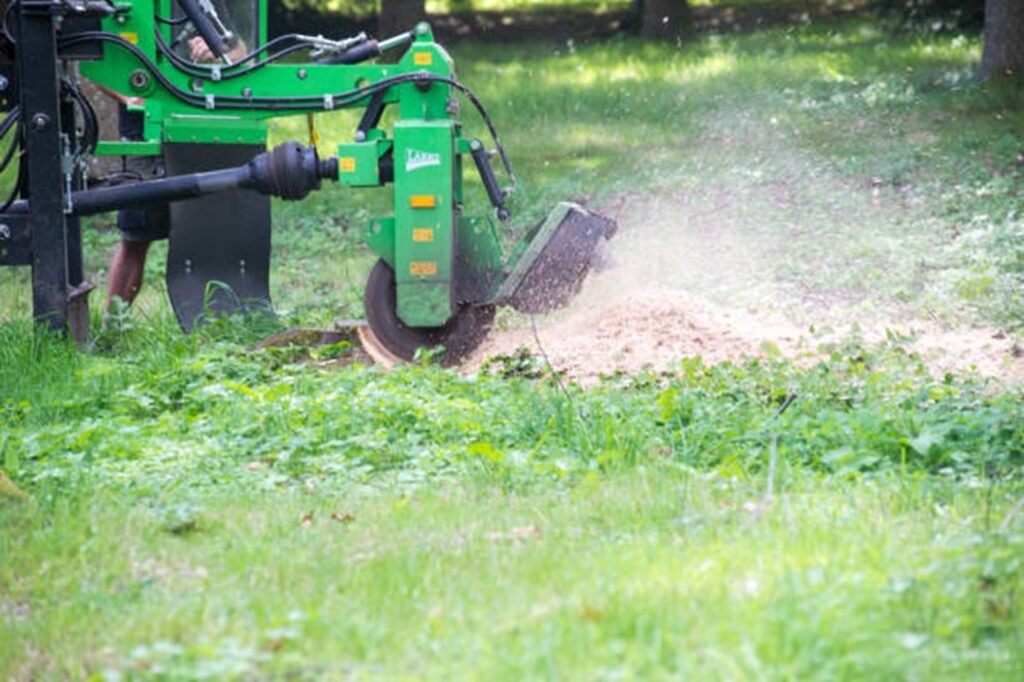 Stump grinding machine removing a tree stump and wood chips in a residential yard in Lyndhurst, OH